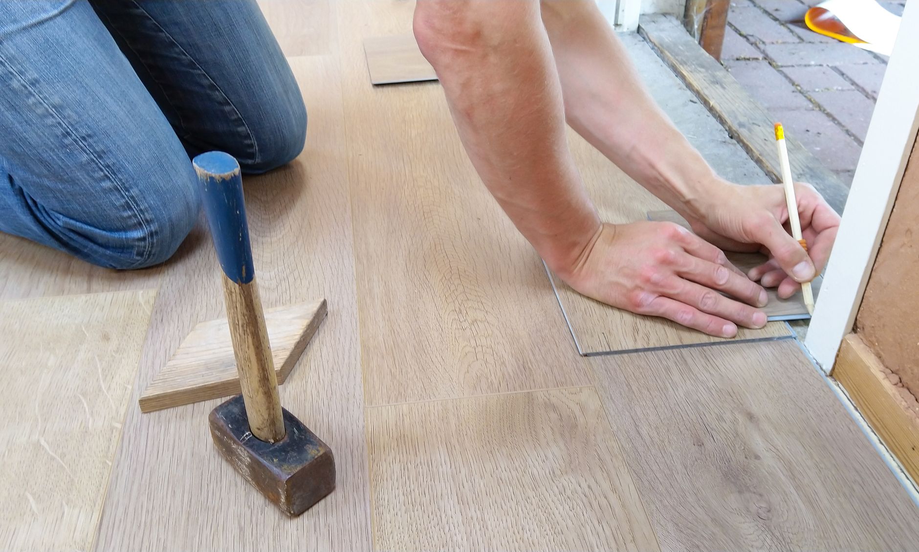 Instalador de suelos colocando parquet en una vivienda de Valencia